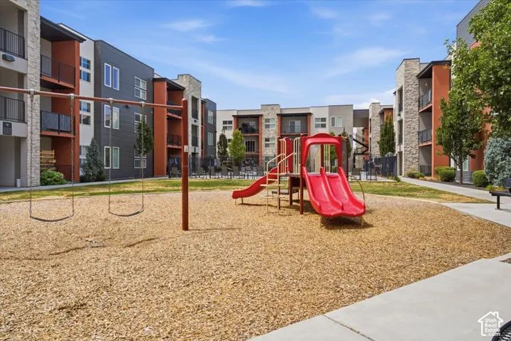 Property playground featuring a swing set, red slide structure, and wood chip surfacing
