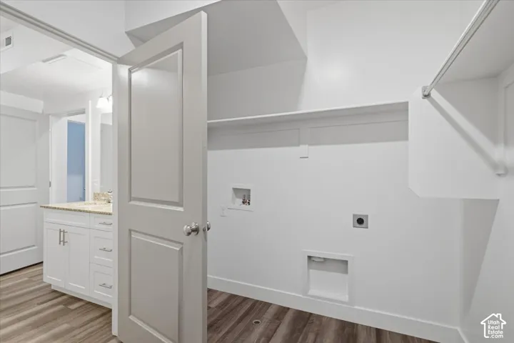 Dedicated laundry area featuring a built-in shelving unit and clothes rod