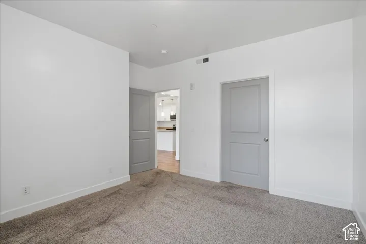 Neutral-toned carpet flooring and white walls with contrasting gray trim