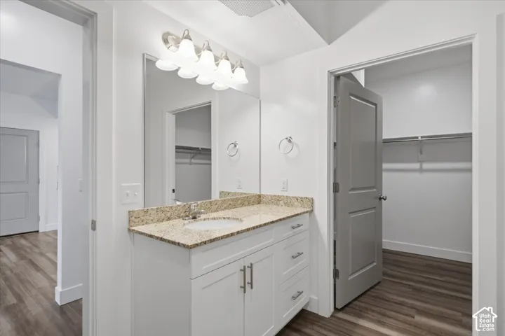 Bathroom vanity with a granite countertop, undermount sink, and brushed nickel hardware