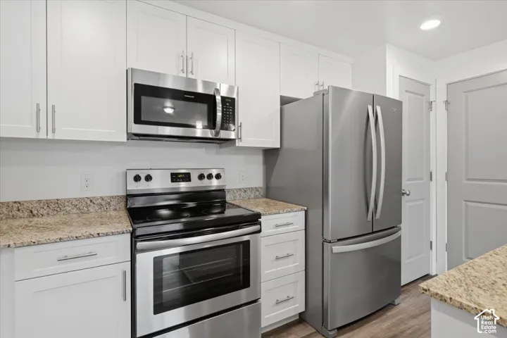 Kitchen featuring stainless steel appliances including a range, microwave, and refrigerator