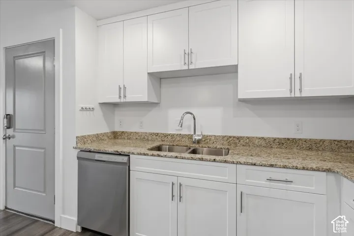Kitchen featuring white shaker-style cabinetry, a stainless steel double-basin sink with a gooseneck faucet, light-toned granite countertops, and a stainless steel dishwasher