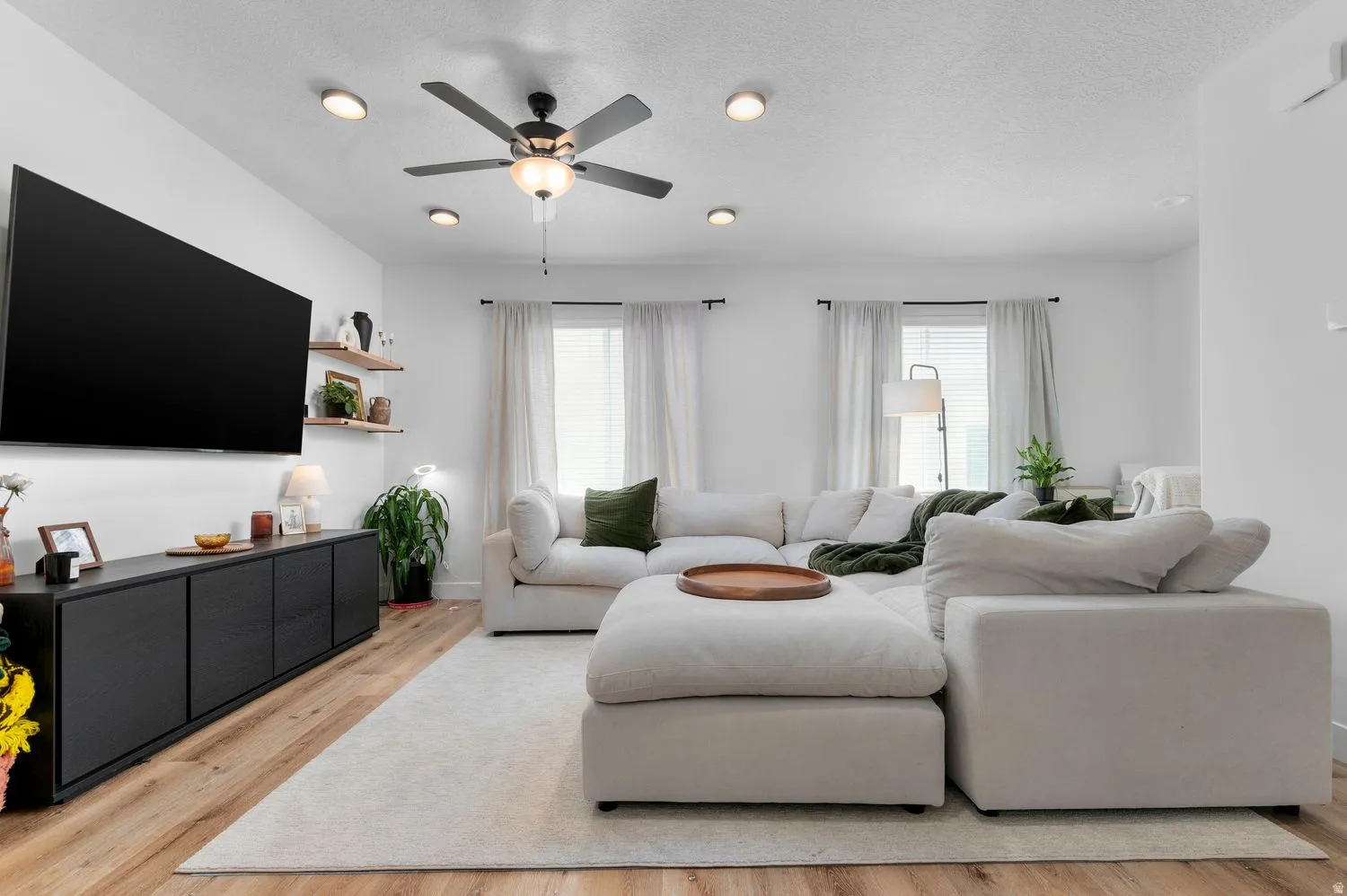 Living area featuring recessed lighting, a ceiling fan, light wood-finish flooring, and white walls