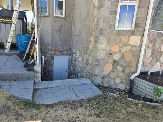 Stone and stucco exterior with a walk-down entryway
