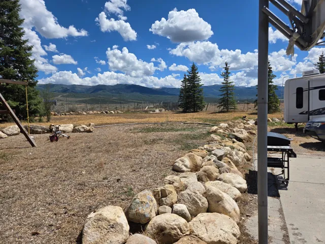 Mountain backdrop and natural landscaping with a stone border