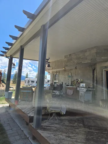 Covered wood-finish deck with a built-in outdoor kitchen area