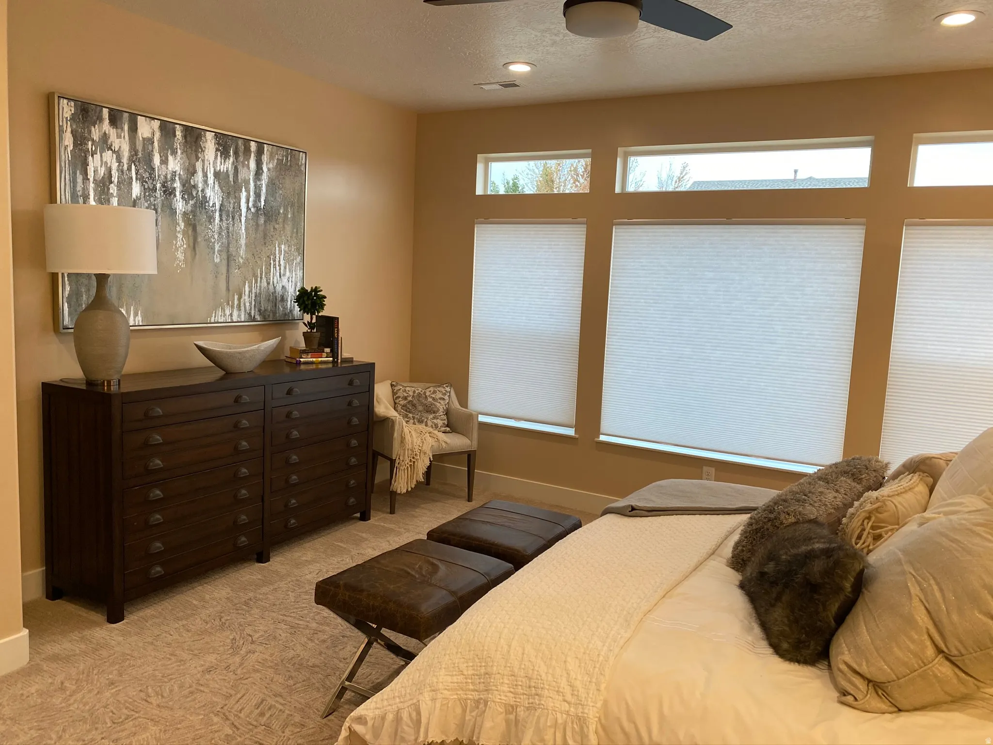 Recessed lighting illuminates neutral-toned walls and plush patterned carpeting
