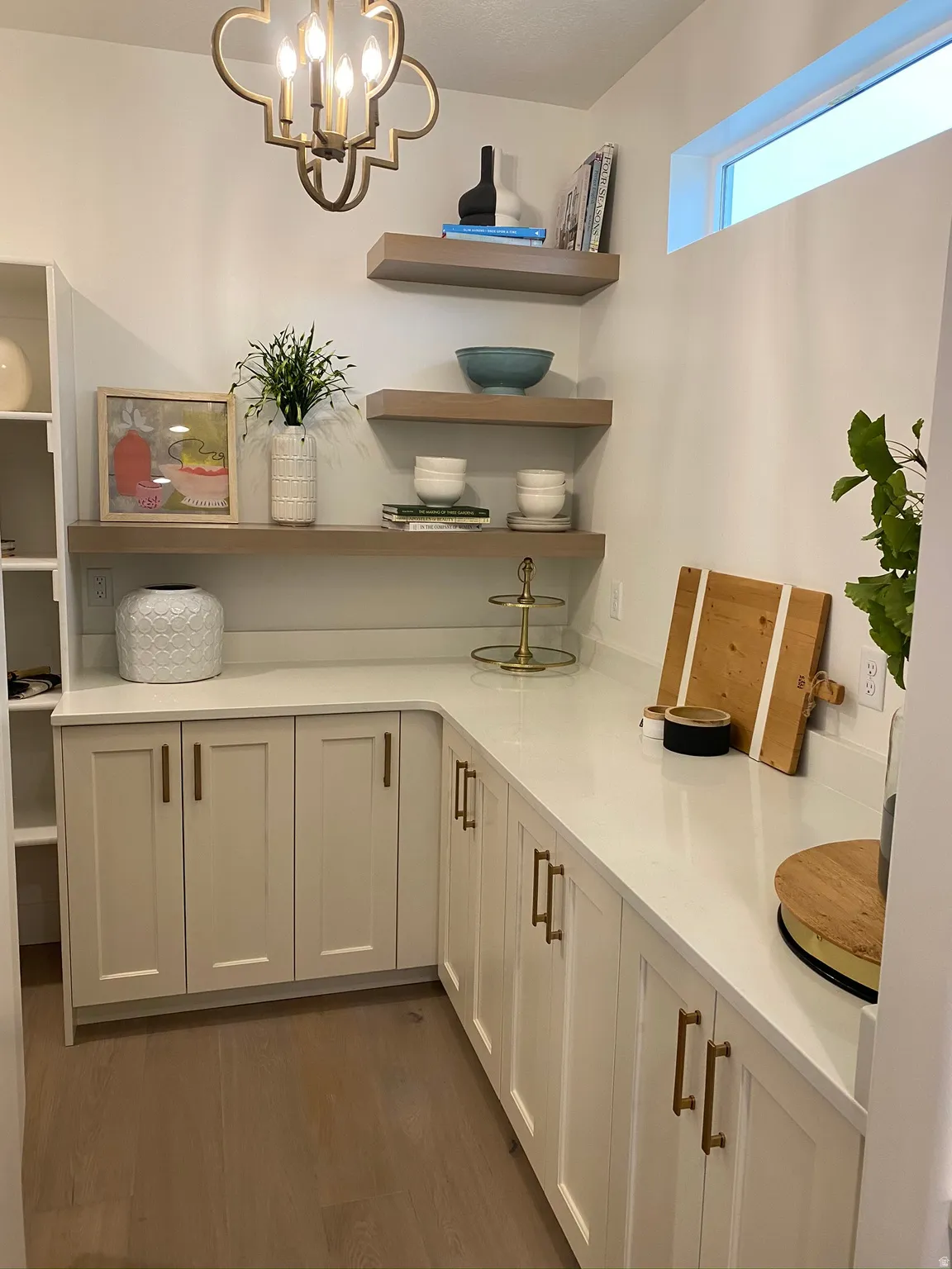 Built-in cabinetry with brass hardware and light-toned countertops