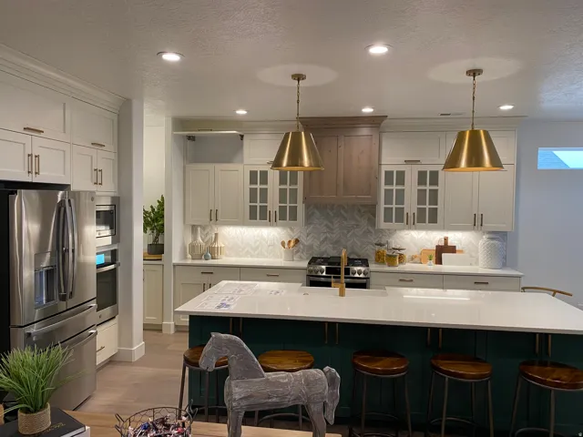 Contemporary kitchen featuring a large island with seating, stainless steel appliances, and a chevron pattern backsplash