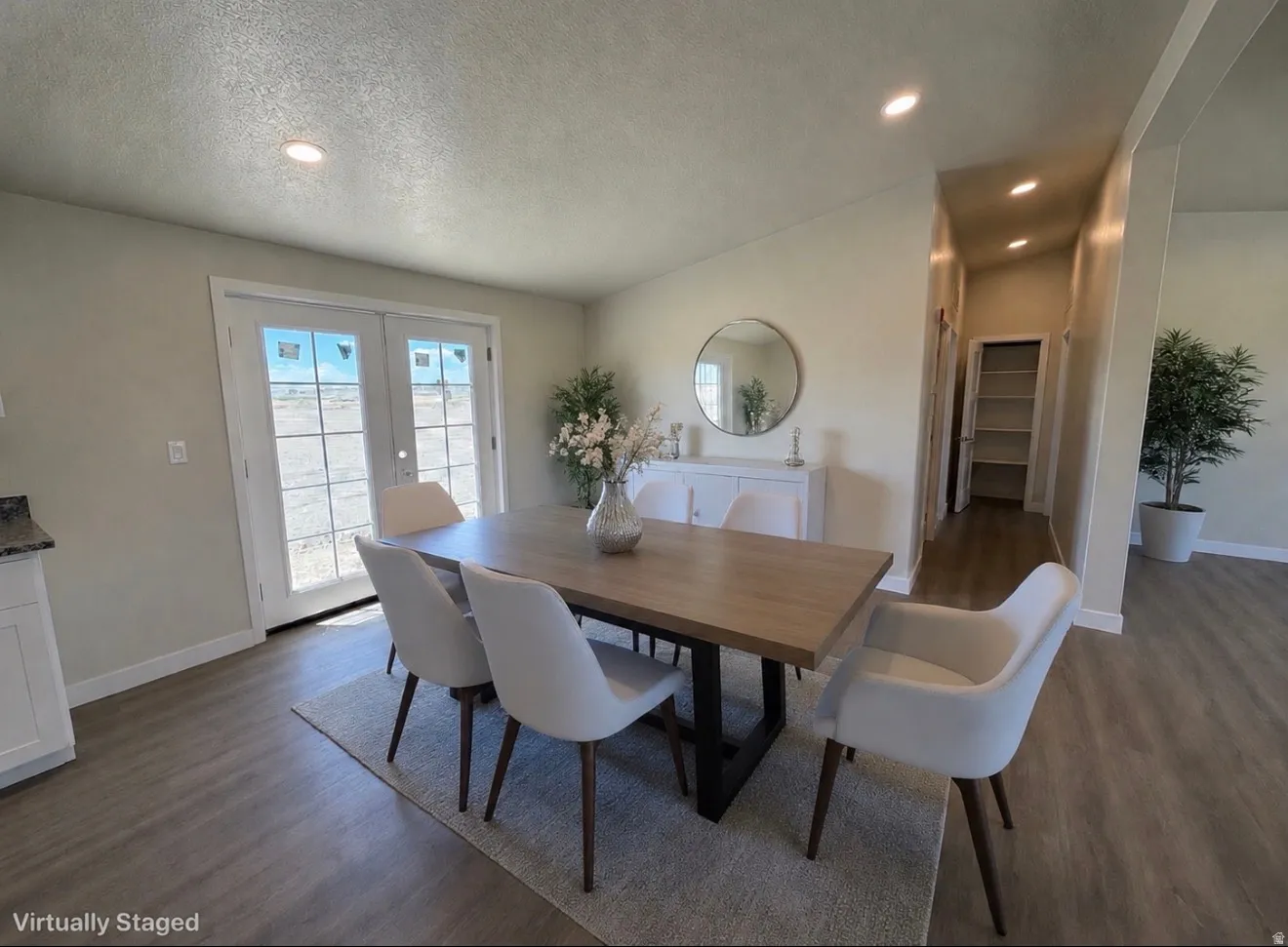 Open-concept dining area featuring wood-finish flooring, recessed lighting, and double glass French doors