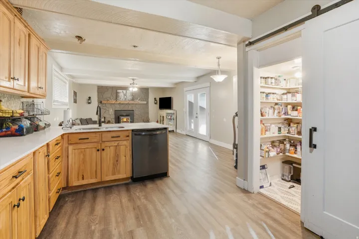 Kitchen featuring natural wood cabinetry, white countertops, and a black appliance package