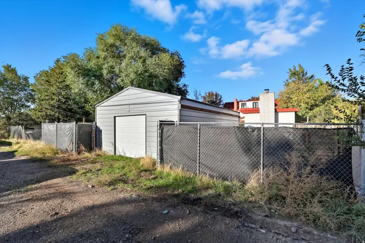 Detached metal garage featuring a roll-up door and a gable roof