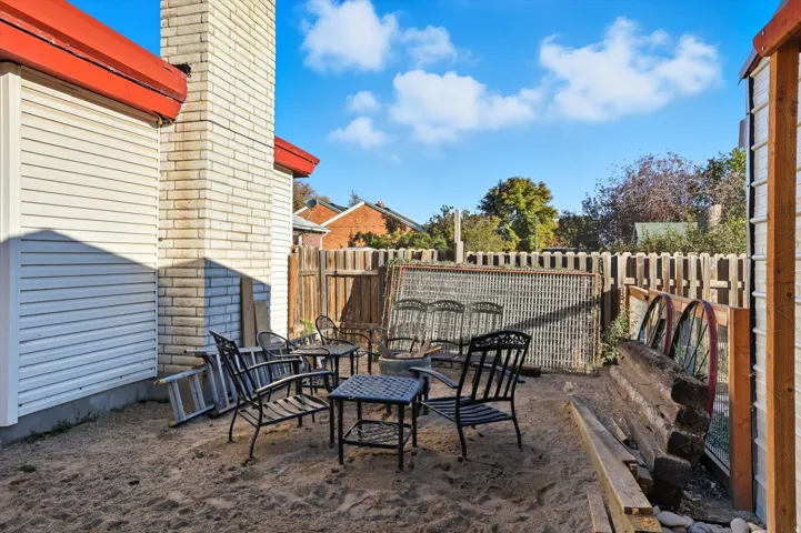 Outdoor patio area featuring a sand base and perimeter fencing
