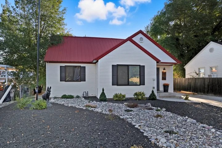 White horizontal siding exterior with a vibrant red metal roof