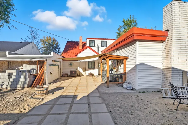Rear exterior featuring a red metal roof and white siding