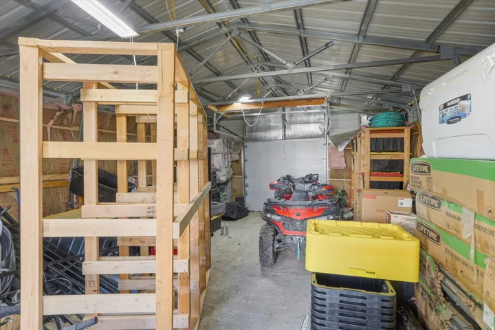 Spacious utility building with a metal frame roof structure, concrete flooring, and an insulated rear wall