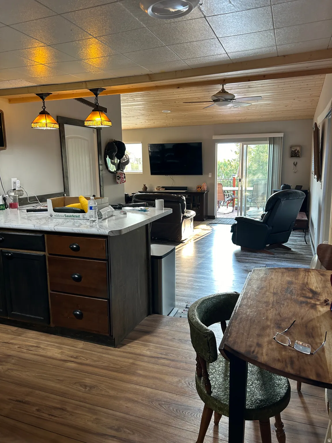 Open-concept living area featuring wood-finish flooring, a wood plank ceiling, and sliding glass doors to exterior