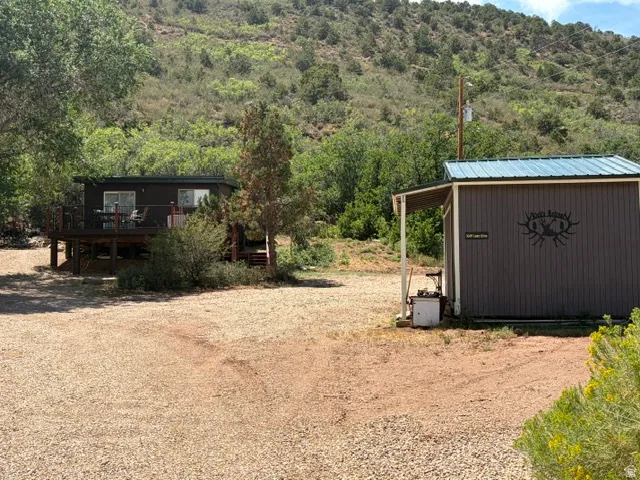 Raised cabin with a spacious deck, surrounded by mature trees