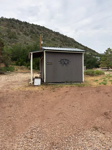Utility shed with a covered porch and metal roof