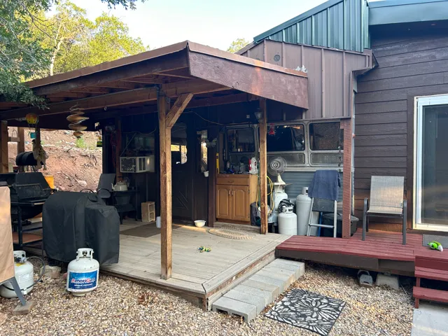 Outdoor covered patio featuring a wood-finish deck and exposed beam ceiling