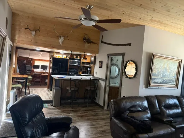 Open-concept living space featuring wood-finish flooring and a wood-paneled vaulted ceiling
