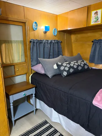 Wood paneling throughout, featuring built-in overhead cabinetry, and integrated wall sconces