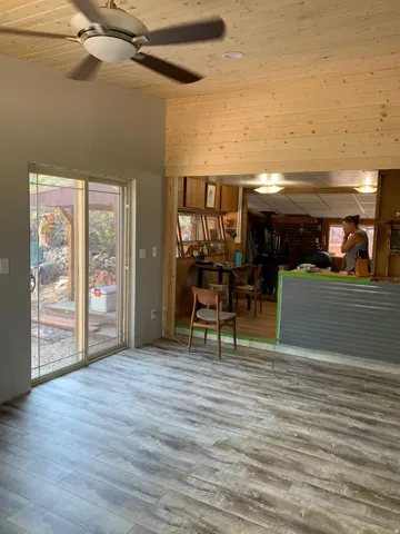 Vaulted wood-paneled ceiling with a ceiling fan