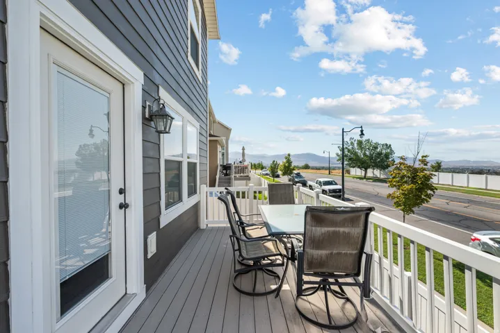 Outdoor deck featuring composite decking, white railing, and exterior siding