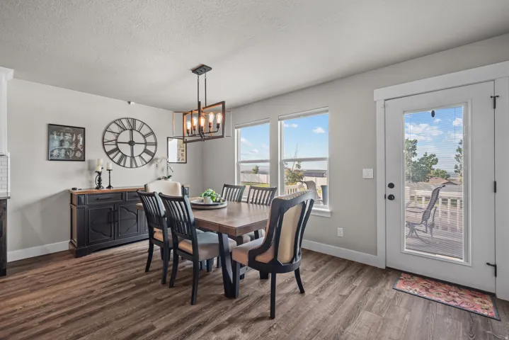 Dining area featuring wood-finish flooring, light gray walls, and multiple windows