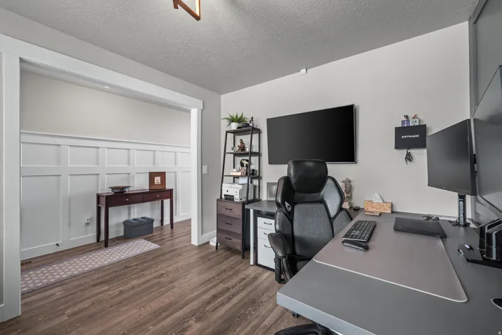 Dedicated office space featuring wood-finish flooring, light gray walls, and a recessed ceiling
