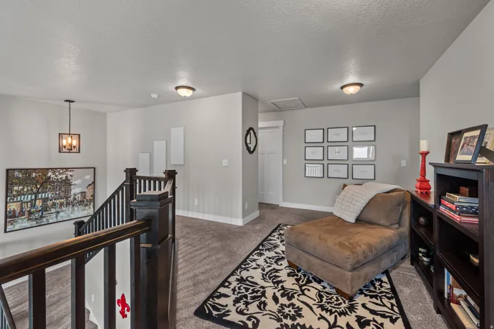 Carpeted landing featuring dark wood newel posts and railings