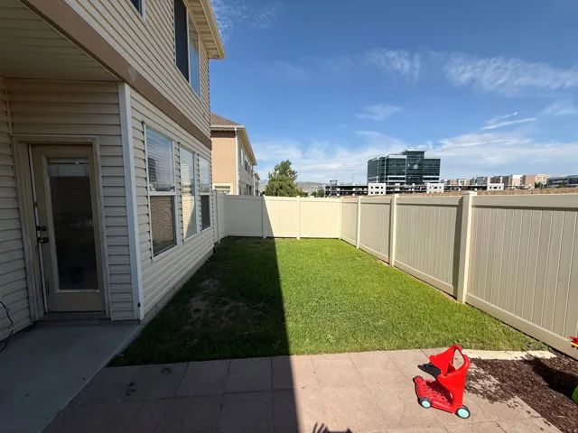 Private backyard featuring a fenced perimeter, a grass lawn, and a stamped concrete patio
