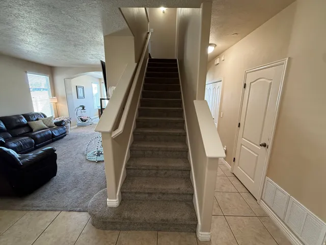 Carpeted staircase with light-toned walls and white trim