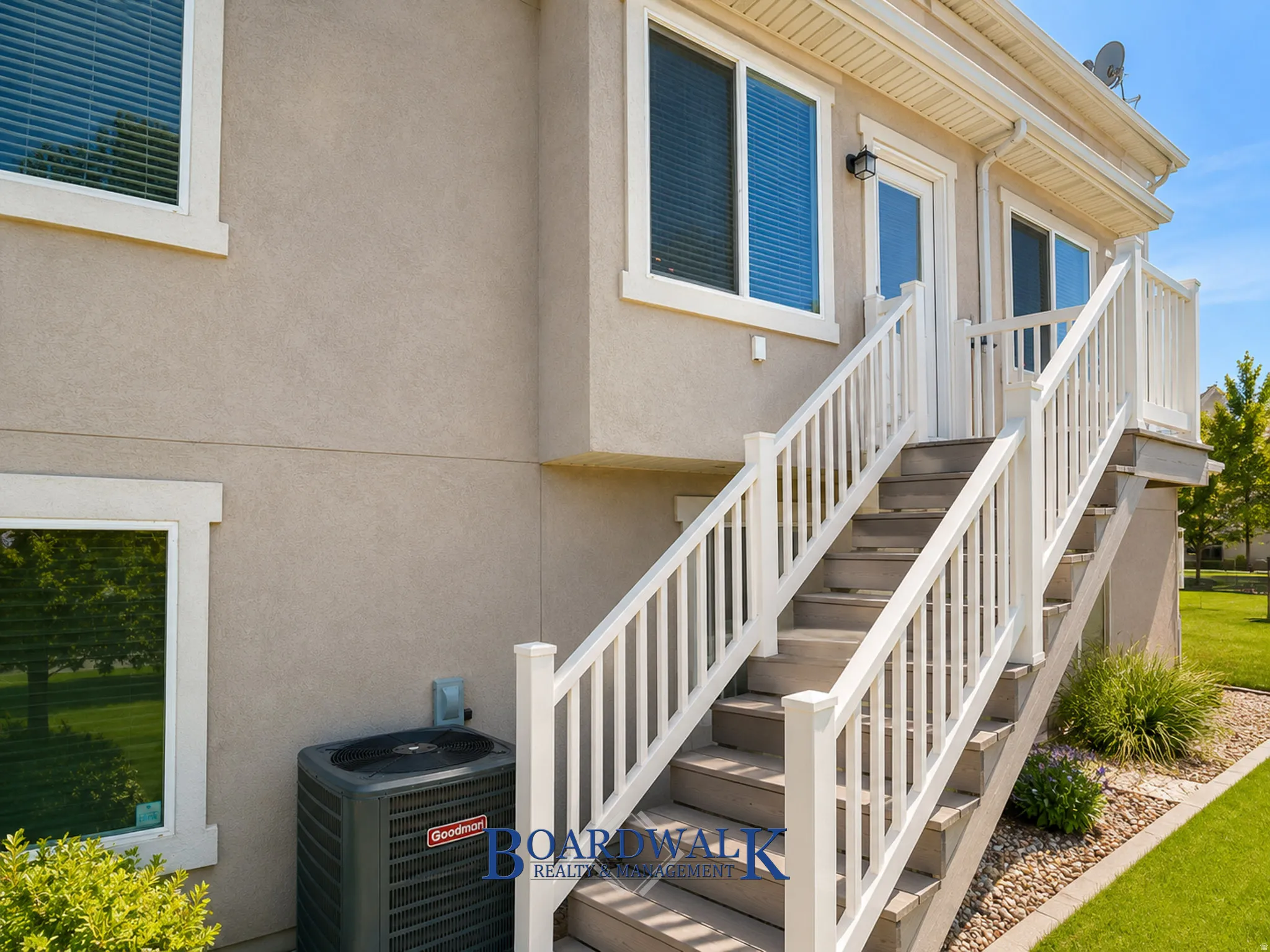 Exterior staircase with white railings providing direct access to an upper-level entry door