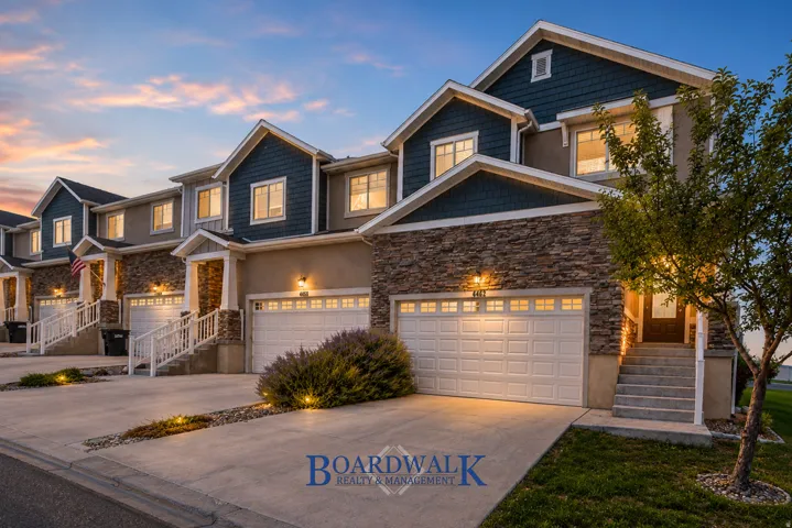 Townhome exterior featuring stacked stone and shingle siding accents