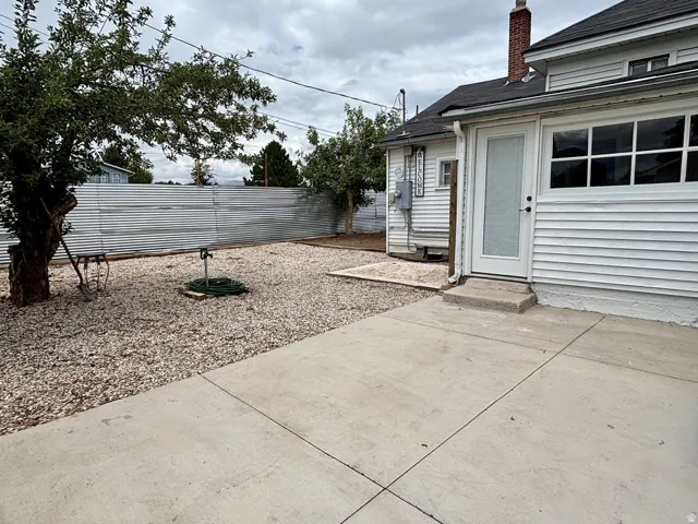 Rear exterior featuring white horizontal siding and a dark shingle roof