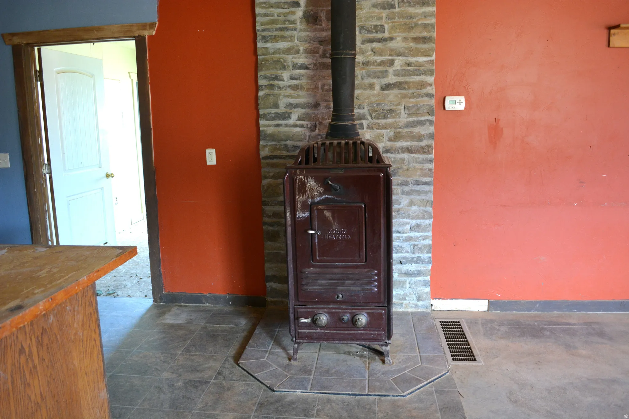 Freestanding stove with stone-finish surround and tile hearth