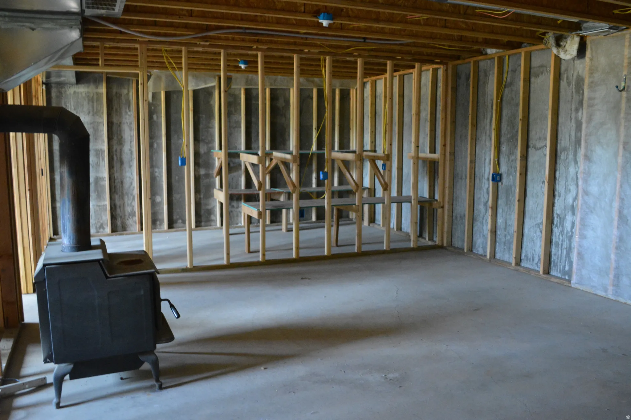 Unfinished basement featuring wood framing and concrete flooring