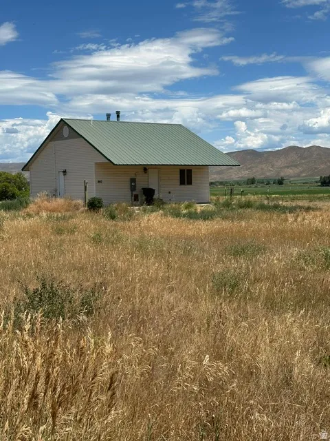 Single-story structure featuring a green metal roof and light-colored siding