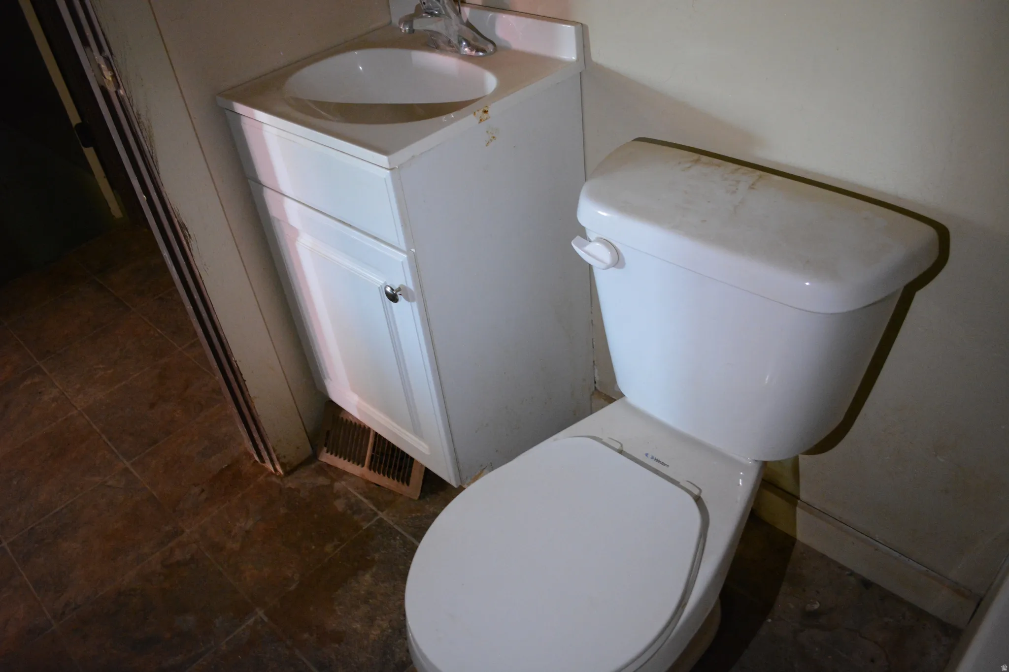 Bathroom featuring a white vanity with an integrated sink, chrome faucet, and white cabinet with a clear knob