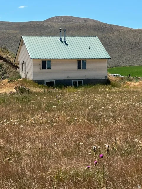 Two-story dwelling with light-colored siding and a green metal roof