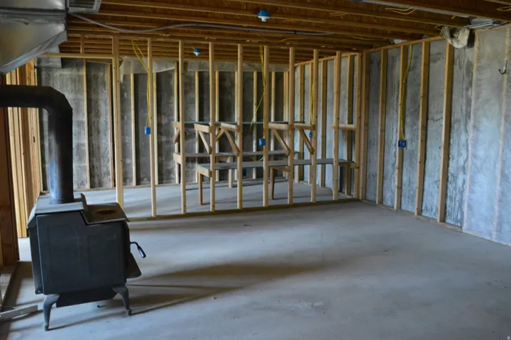 Unfinished basement featuring wood framing and concrete flooring
