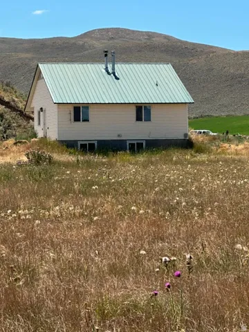 Two-story dwelling with light-colored siding and a green metal roof