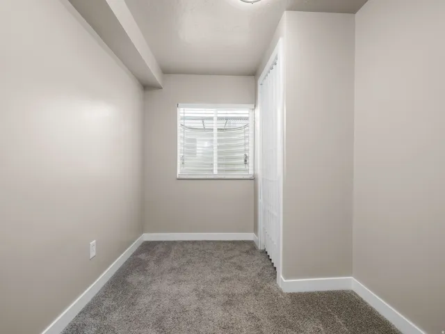 Carpeted room with neutral wall paint and white trim