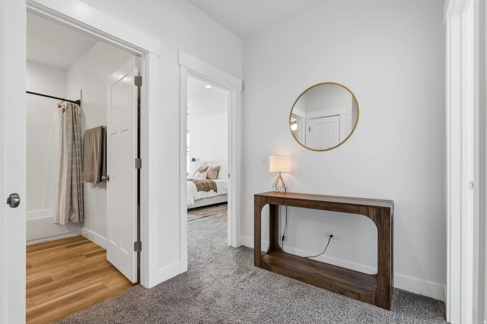 Hallway featuring plush gray carpeting, white walls, and bright white trim