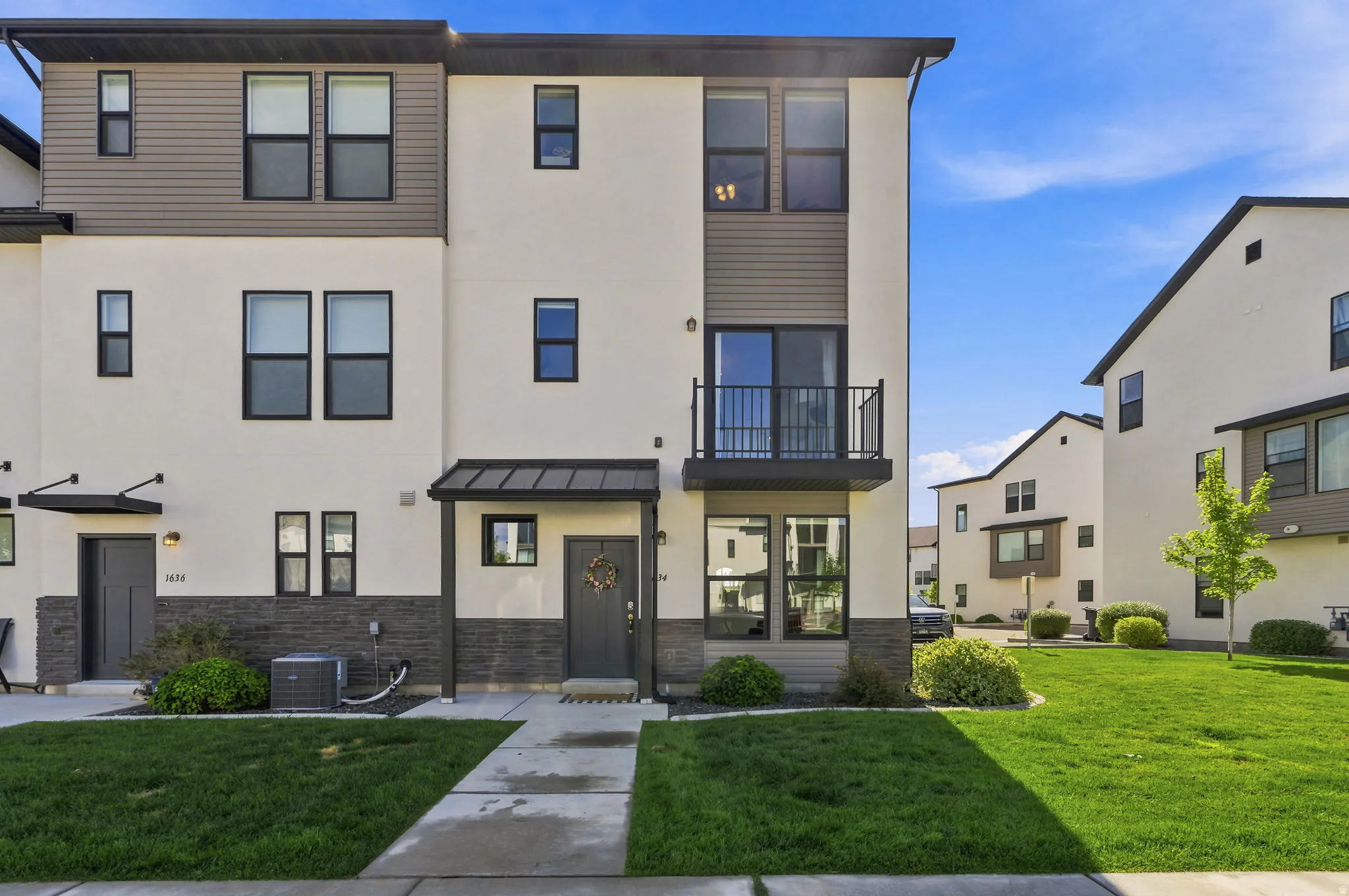Contemporary multi-story facade featuring light stucco and dark horizontal siding