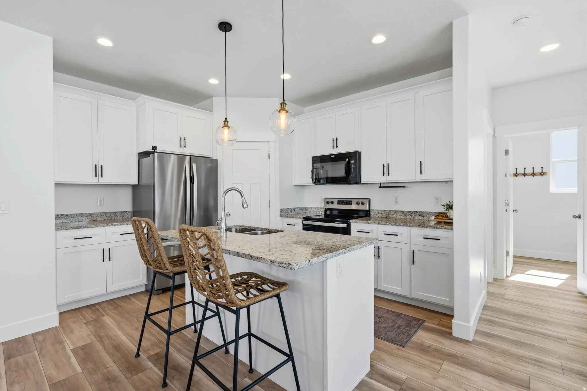 Contemporary kitchen featuring white cabinetry and light-toned countertops