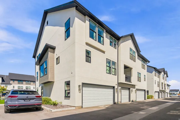 Modern multi-story exterior with light-colored siding and dark trim