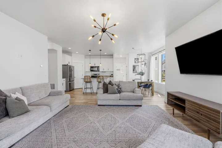 Open-concept living space featuring wood-finish flooring and a contemporary sputnik chandelier