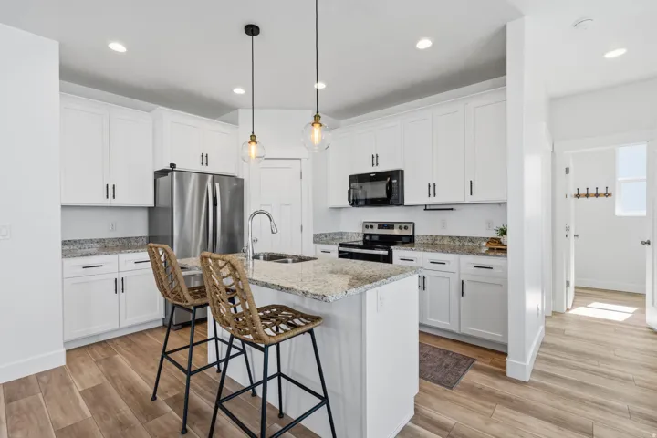 Contemporary kitchen featuring white cabinetry and light-toned countertops